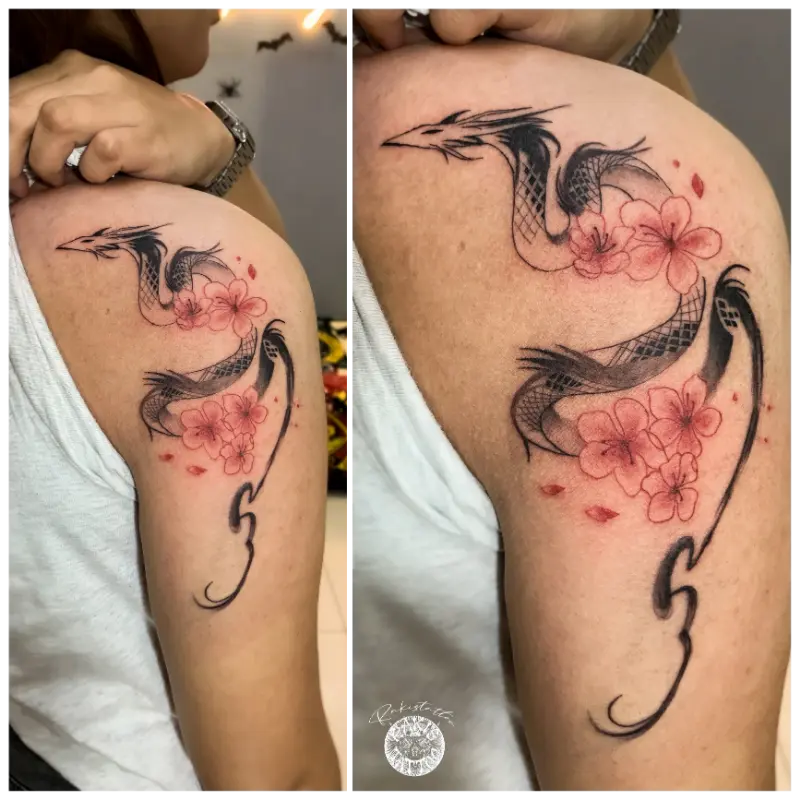 black and grey linework of serpentine dragon with pink cherry blossom flowers